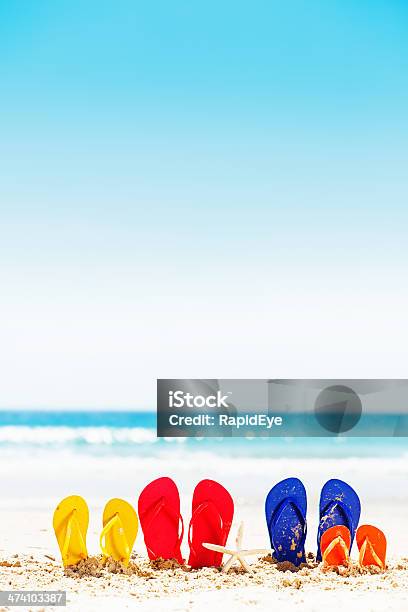 Family Vacation Time Four Pairs Of Flipflops On Summer Beach Stock Photo - Download Image Now