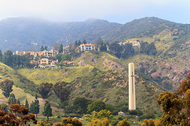Malibu, CA, USA -- April 29, 2012: A thick fog rolls in from the mountains behind the Pepperdine University Campus in Malibu California.  A Christian university, Pepperdine was established in 1937 and currently enrolls a little less than 8,000 students.  The campus is located on a hillside that overlooks the Pacific Ocean.  In  the foreground of the photo you can see the Phillips Theme Tower, a tall slender 125 foot tower made of stucco and steel.  It was completed in 1973 and features a large cross in the center that can be lit at night.