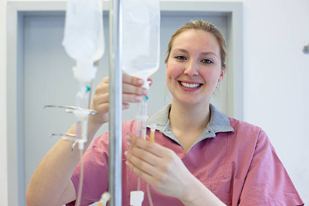 istock blond female nurse prepares an IV Drip 474107135