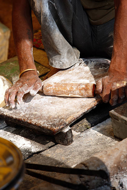 istock Indian man rolling out chapati bread dough 474108733