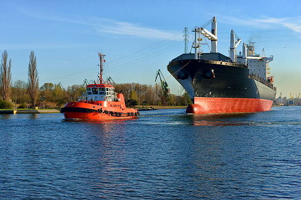 istock Large ship escorted by tugs in the harbor 474110608