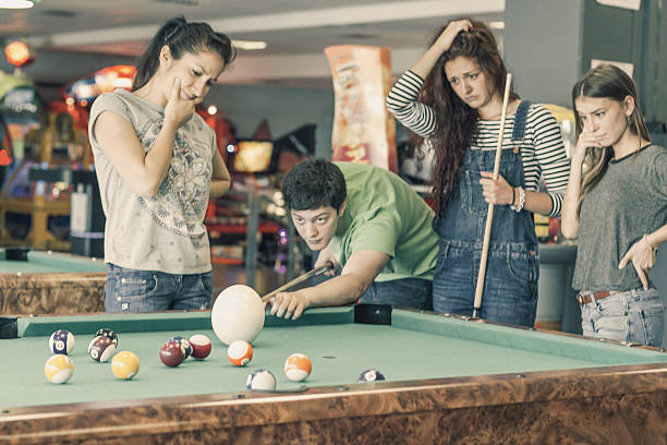 istock Young friends playing pool or billiard with ostrich egg 474110906