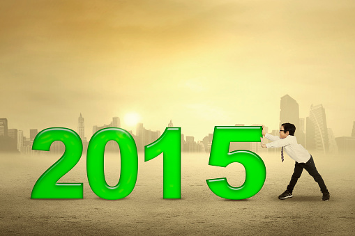 Little boy pushing number 2015, symbolizing happy new year
