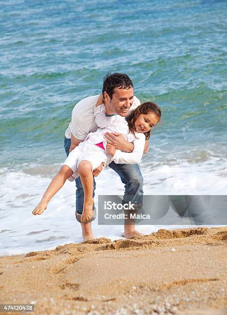 Father And Daugther Playing In A Beach Stock Photo - Download Image Now - 2015, 4-5 Years, Adult