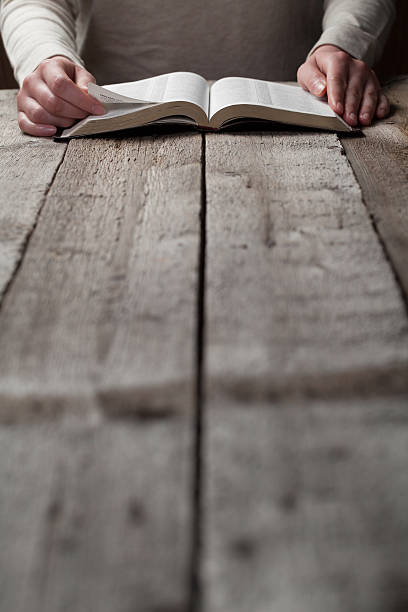 istock Woman reading Bible on wooden table 474127914