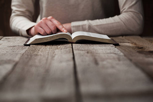 istock woman finger presses on bible book 474128012