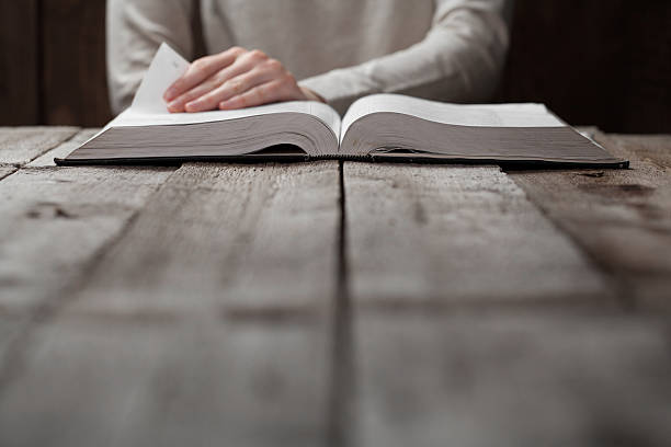 istock woman finger presses on bible book 474128070