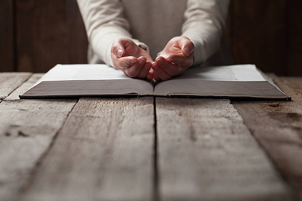 istock woman hands on bible. 474128158
