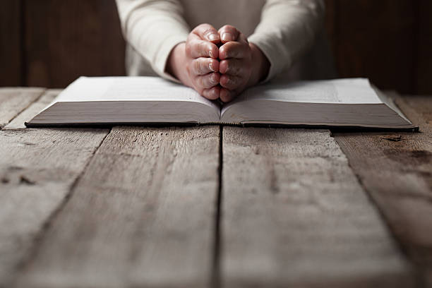 istock woman hands on bible. 474128178