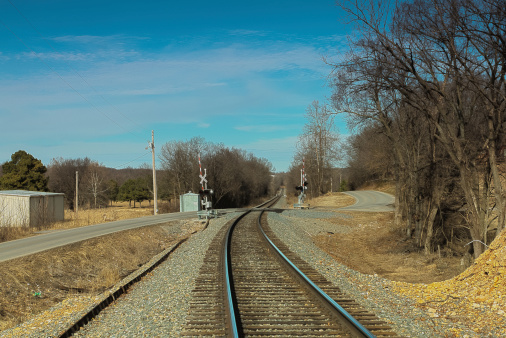 Looking down railroad tracks near a crossing piont.