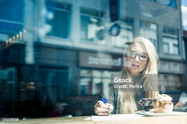 Young Woman With Glasses Writing On Blank Paper Having Coffee Stock Photo - Download Image Now