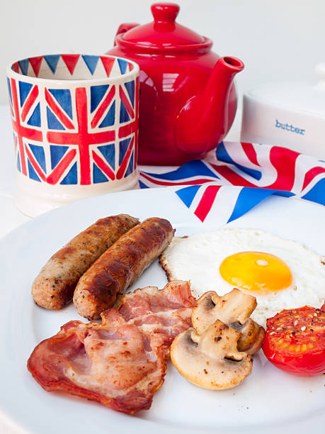 istock Bacon and eggs with teapot, mug, british flag behind 474145583