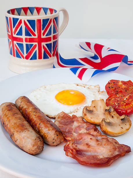 istock english fried  breakfast  with  tea mug and british flag behind 474145587