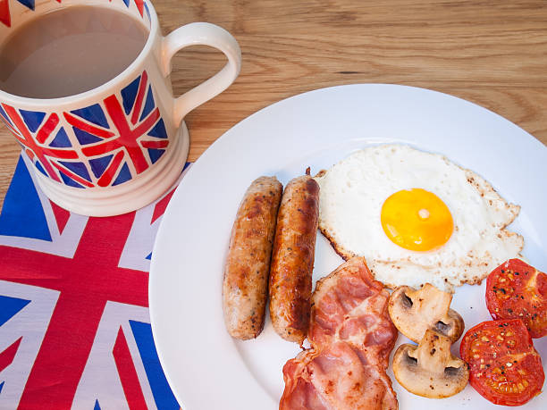 istock Cooked breakfast with cup of tea and british flag behind 474146171