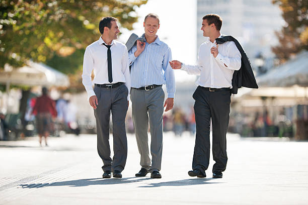 Depicting three young men, making an executive team in a successful company. They're having a good laugh while posing for the camera.