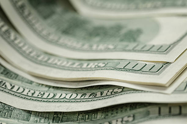 istock hundred dollar bills on wood table 474148392