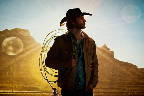 istock Smiling cowboy holding lasso and looking away 474155240
