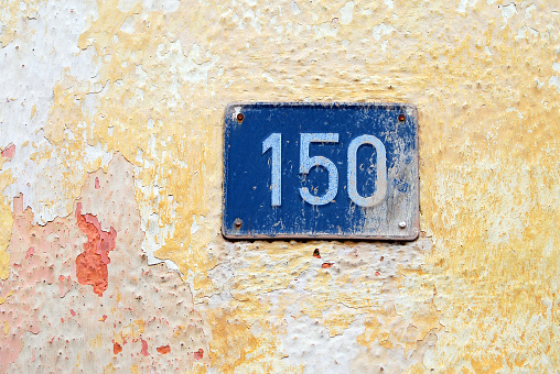 House address plate number (150) hanging on wall