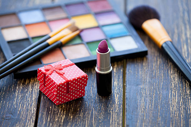 istock Gift box and brushes for makeup on wooden table. 474158510