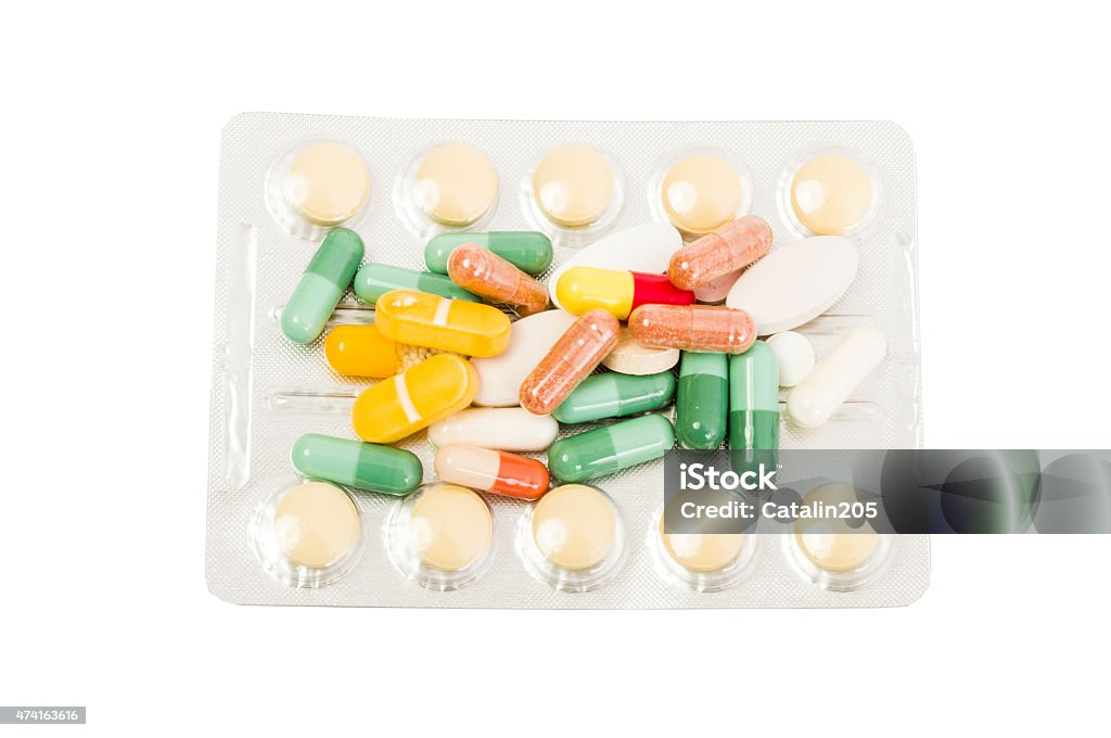Blister and pills Blister and various colorful pills on white table 2015 Stock Photo
