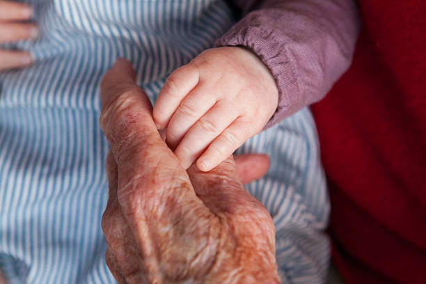 istock Grandmother holding a newborn baby's hand 474167196