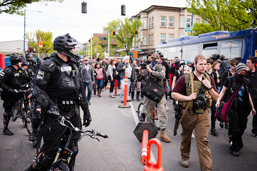 Seattle, USA - May 1, 2015: A man carrying an SKS assault riffle exercising his 2nd amendment rights, while marching with other protesters in the Anti Capitalist protest down Broadway Avenue on Capitol Hill next to the Seattle Police late in the day.   