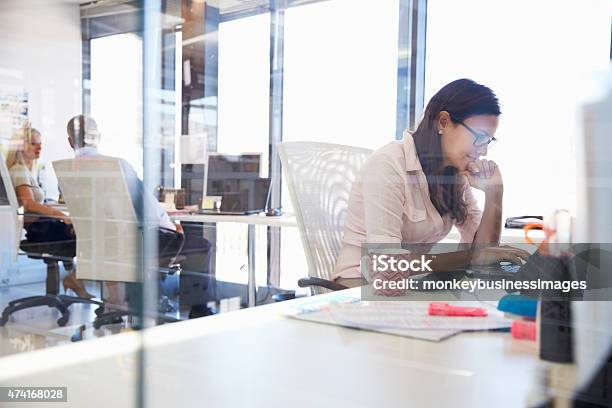 Mujer Trabajando En Equipo En La Oficina Foto de stock y más banco de imágenes de 20 a 29 años - 20 a 29 años, 2015, Adulto