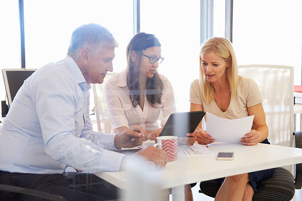 istock Group of colleagues meeting around a table in an office 474168068