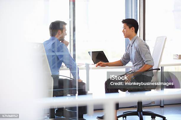 Two Men Working In A Modern Office Stock Photo - Download Image Now - Discussion, Talking, Asian and Indian Ethnicities