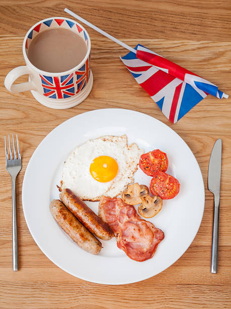 istock Full english breakfast with cup of tea and british flag 474171725