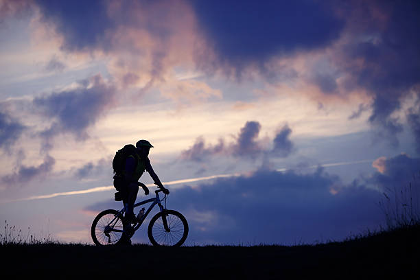 istock Man mountain bike clouds blue 474173768