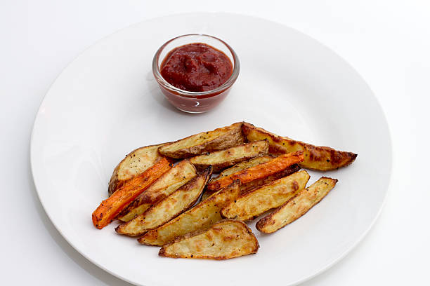 istock Oven baked potatoes and carrots with ketchup 474174427