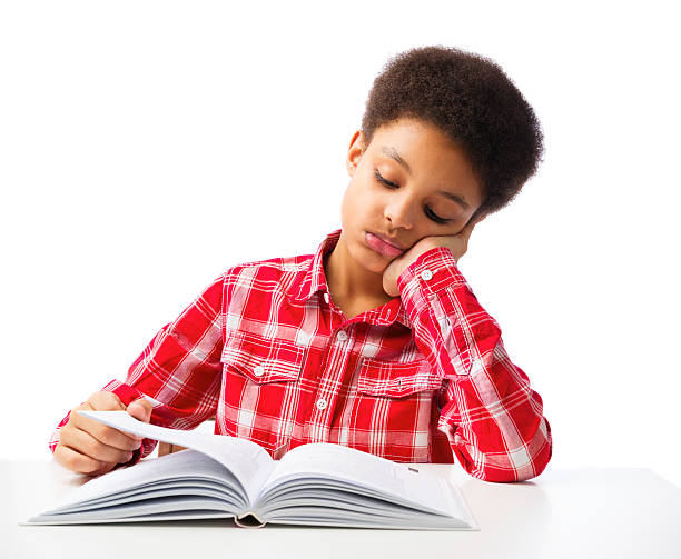 African American school boy reading book without interest Bored African American school boy reading book without interest, education and school concept. Over white background, isolated, with copy space boring homework twelve stock pictures, royalty-free photos & images