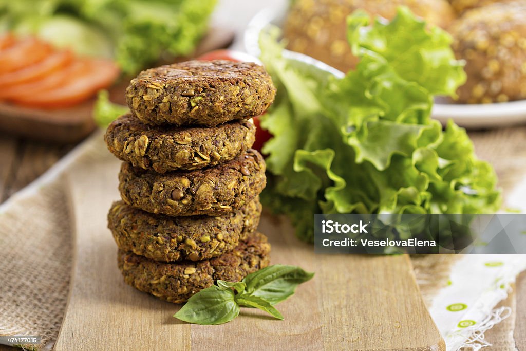 Vegan burgers with lentils and pistashios Vegan burgers with lentils and pistashios stacked on a cutting board Backgrounds Stock Photo