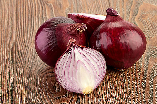 istock Fresh red onions on a wooden background 474177309