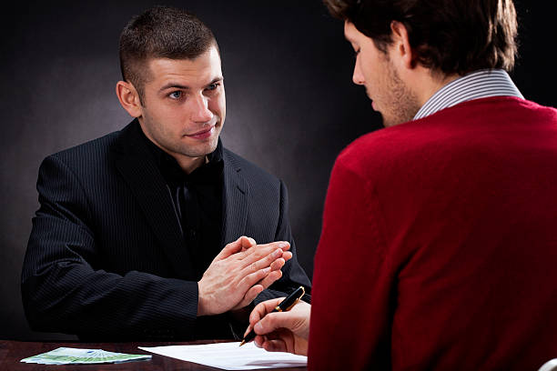 Moneylender talking with client Moneylender convincing client to sign usury contract leather pocket clothing hide stock pictures, royalty-free photos & images