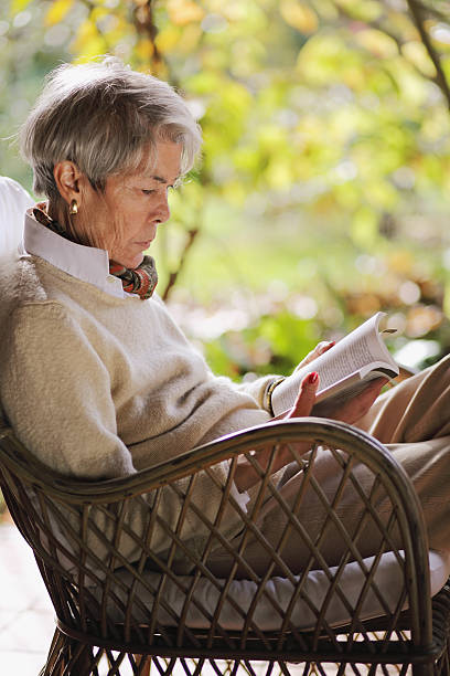 istock Mature lady reading and relaxing  outdoors 474178017