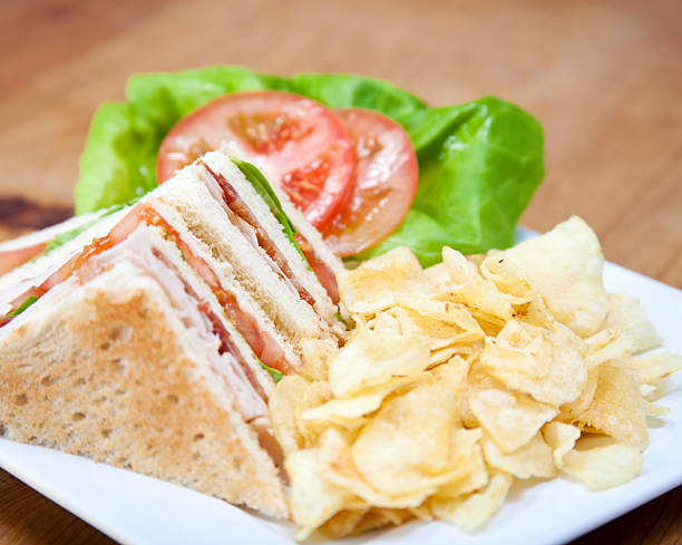 турция клубный сэндвич и чипсы на деревянном столе - sandwich delicatessen bacon lettuce and tomato mayonnaise стоковые фото и изображения