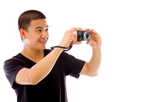 Side view of male photographer using a DSLR camera. Vertical shot. Isolated on white.