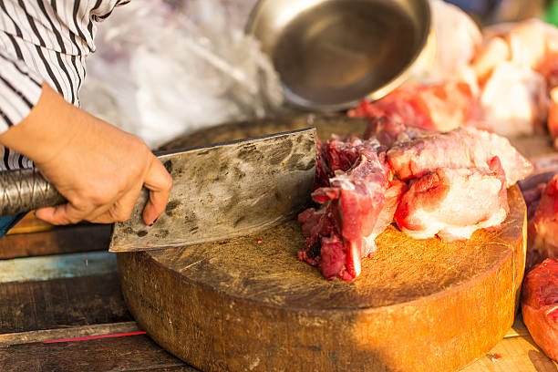 istock Butcher Using Meat Cleaver to Cut Raw Meat 474183558