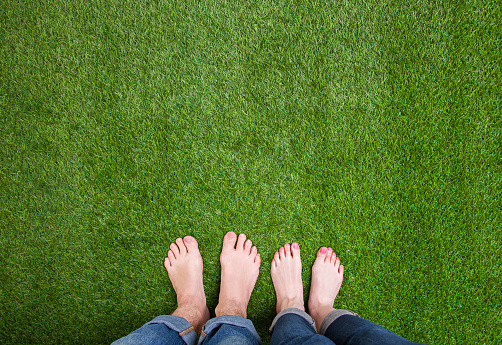 Couple legs standing together with love on summer grass