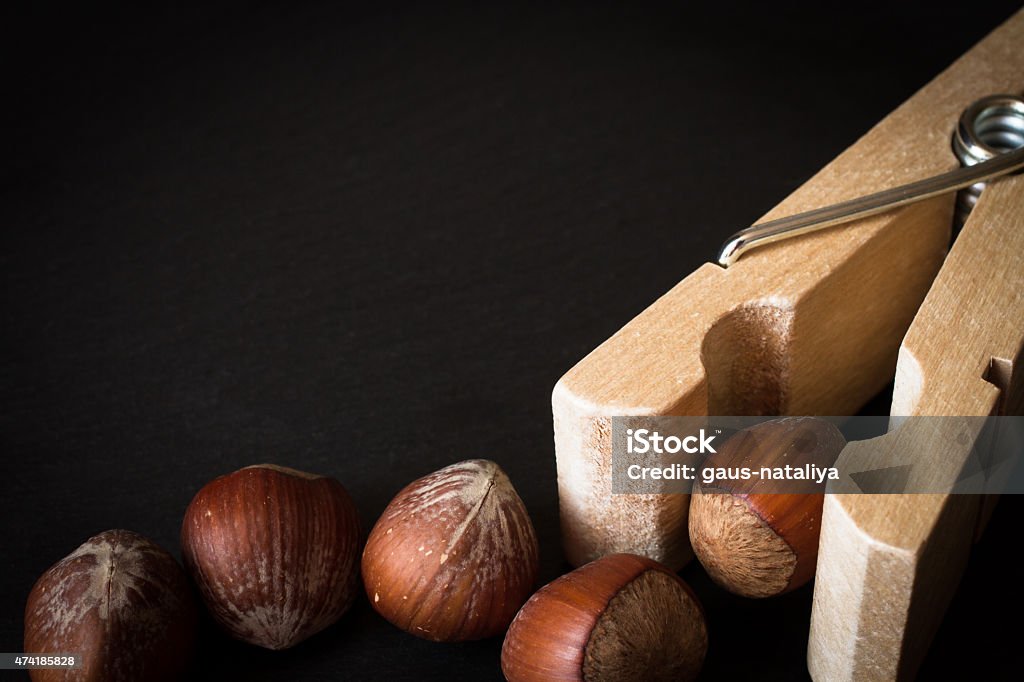 hazelnuts in shell with clothespins hazelnuts in shell with clothespins on a black background 2015 Stock Photo