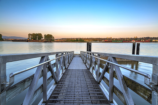 aluminium alloy bridge leading to the floating fishing dock at sunset