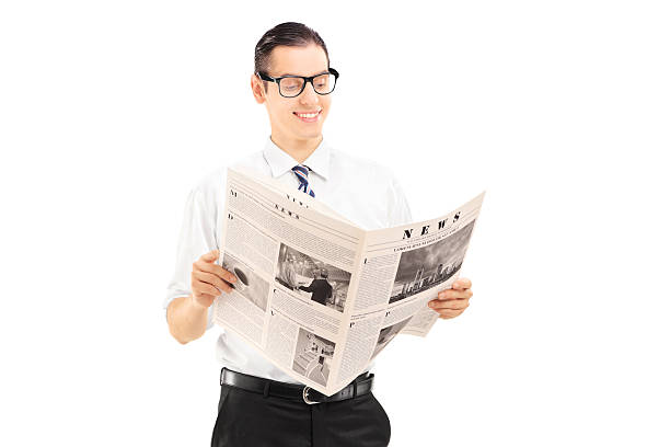 istock Young businessman standing and reading a newspaper 474189759