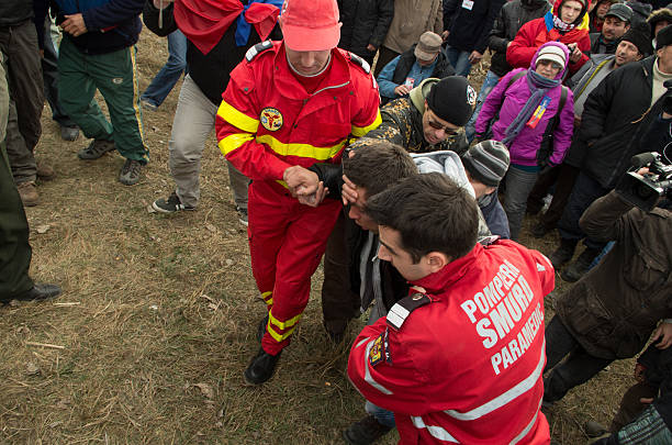 Protestor and Paramedics Pungesti, Romania - December 7, 2013: Anti Fracking activist directed to ambulance by paramedics during protest against fracking at midday December 7, 2013 in Pungesti, Romania. riot police stock pictures, royalty-free photos & images