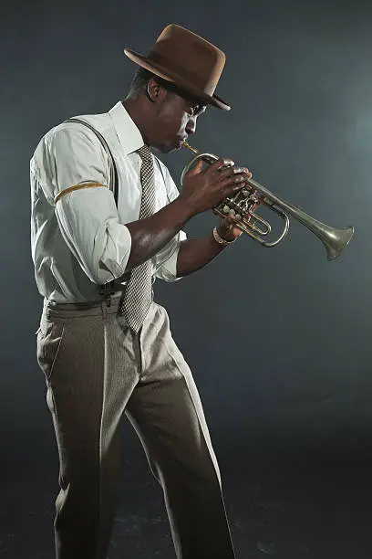 Photo of Black african american jazz trumpet player. Vintage. Studio shot.