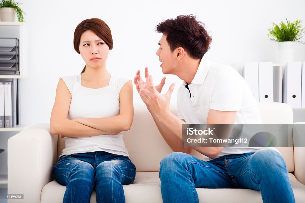 Angry young couple sitting on the sofa 2015 Stock Photo