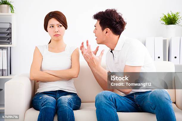 Angry Young Couple Sitting On The Sofa Stock Photo - Download Image Now - 2015, Adult, Aggression