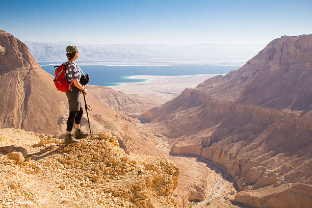 istock Young female standing on mountain's edge looking towards a sea. 474201339