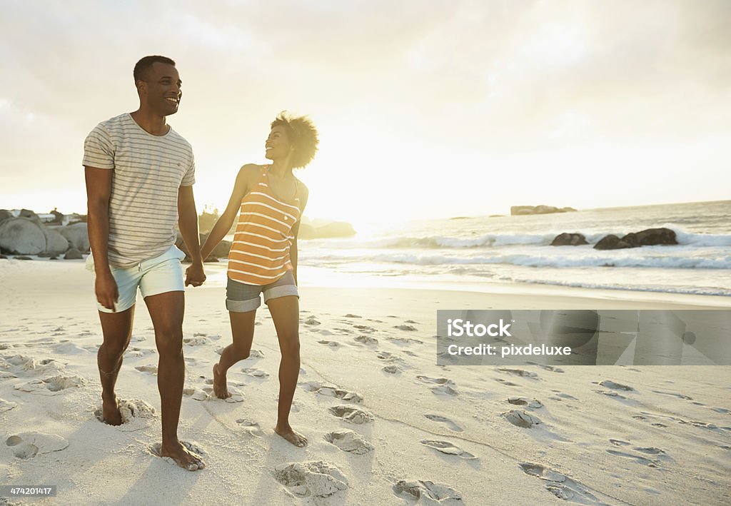 We should take a walk every day... A young couple holding hands while walking on the beach Beach Stock Photo